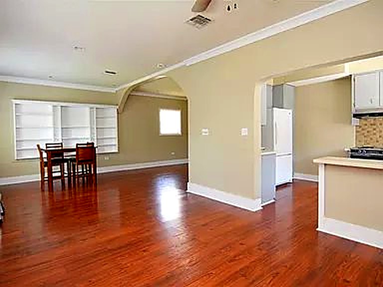 Open living area before the remodel: beige walls and dated flooring